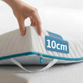 Hand tilt de hoek op van de Ella matrastopper van 10 cm met gewatteerde hoes en turquoise rits.