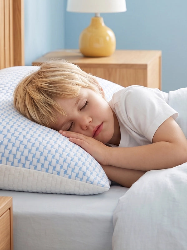 Kind slaapt op zij op een wit Ella kinderhoofdkussen.