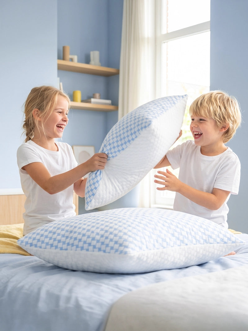 Twee kinderen spelen met witte Ella kinderhoofdkussens.