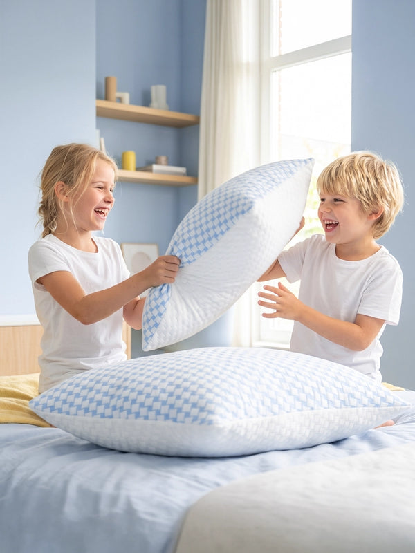 Twee kinderen spelen met witte Ella kinderhoofdkussens.