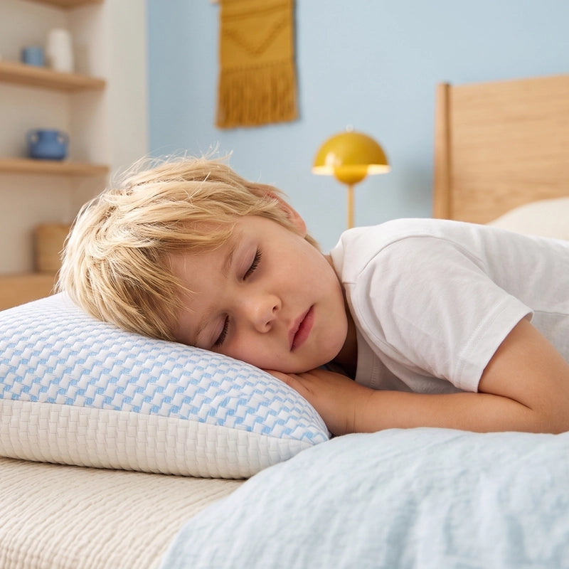 Kind slaapt op zij op een wit Ella kinderhoofdkussen.